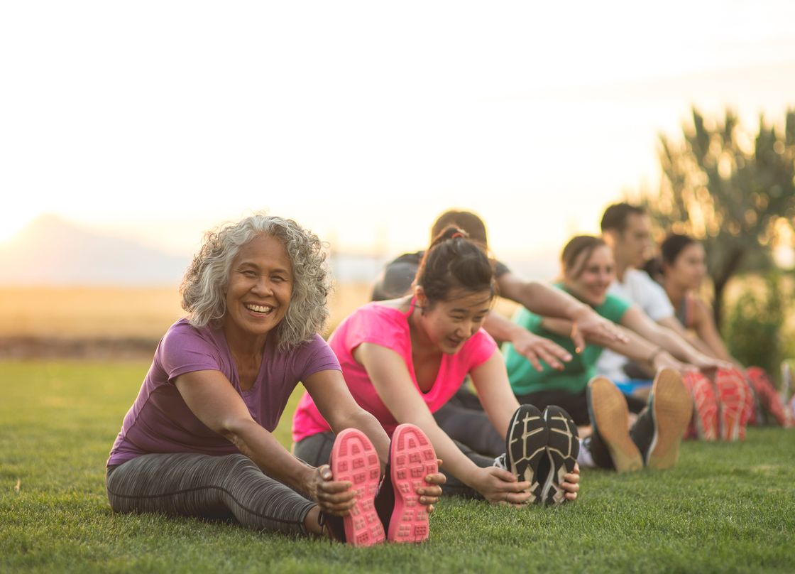 people sitting on a lawn in a park during golden hour