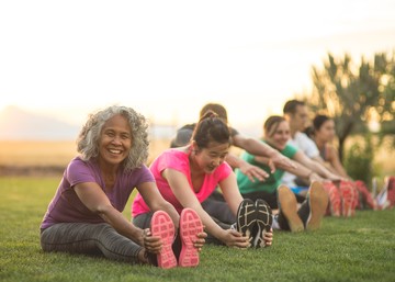 people sitting on a lawn in a park during golden hour
