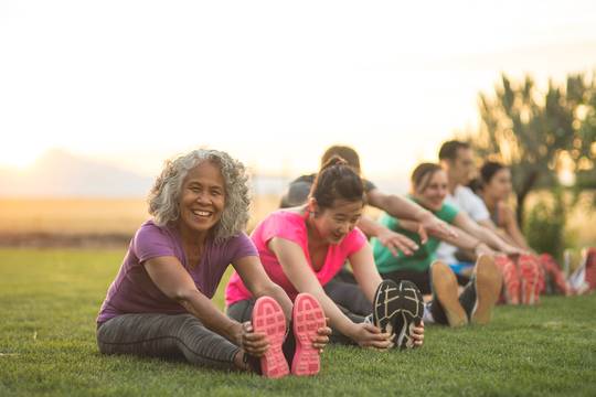 people sitting on a lawn in a park during golden hour